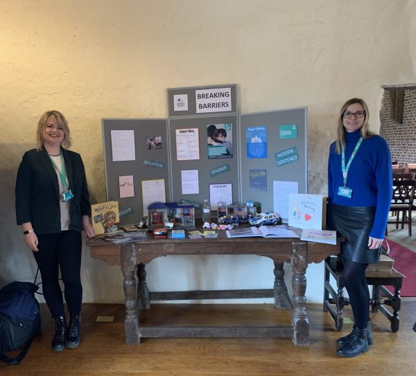 Staff from Ormiston Families stand next to a display featuring information about the Breaking Barriers service.