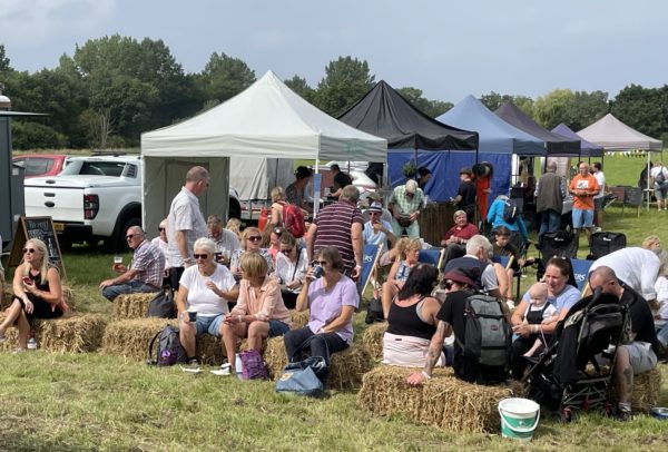 People sit on hay bails at the Walk with a Fork event at Helmingham Hall